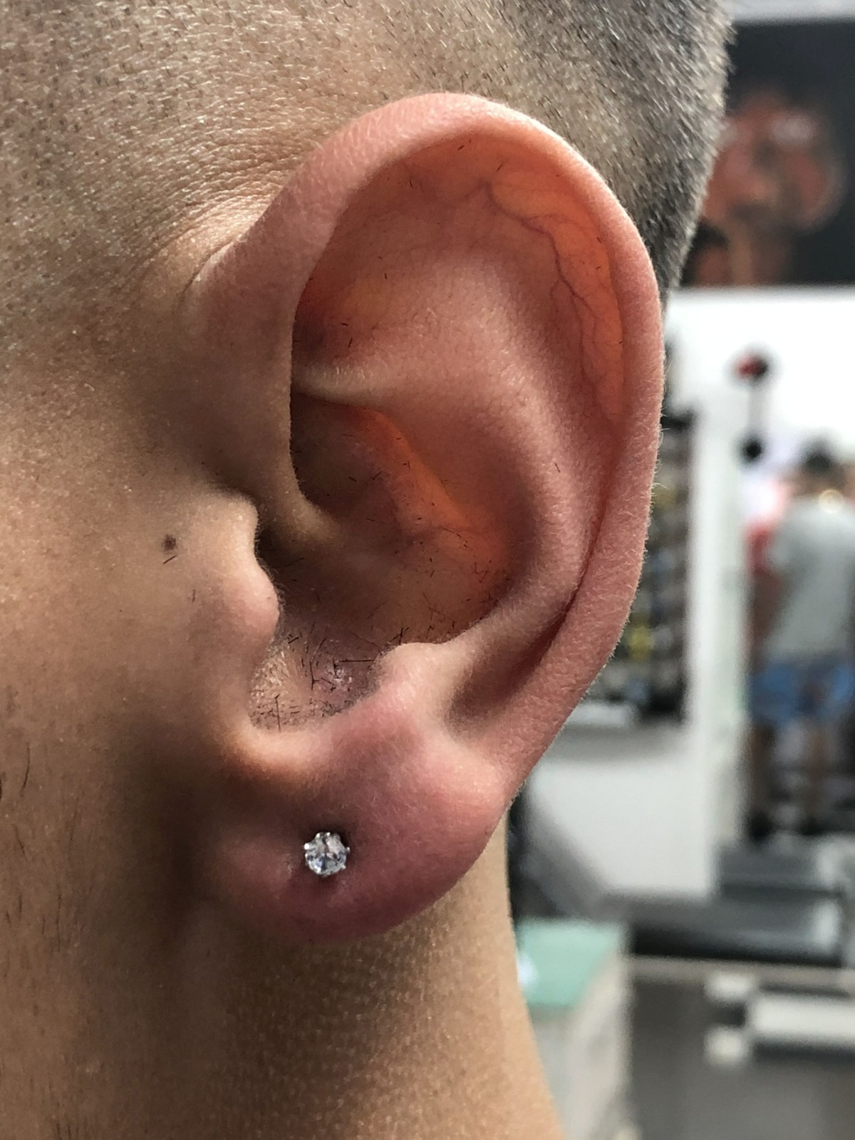 Brinco de zircônia aplicado no lóbulo masculino